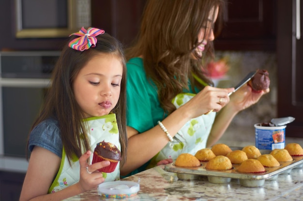 Ella es una gran pequeña panadera Linda niña horneando con su niñera en casa