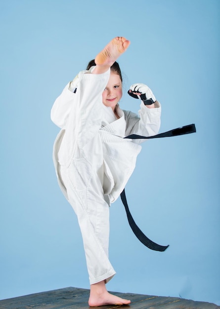 Ella es peligrosa Niña pequeña en kimono blanco con cinturón Luchadora de karate lista para pelear Concepto de deporte de karate Habilidades de autodefensa El karate da sensación de confianza Niño fuerte y confiado