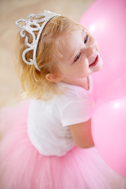 Ella es la princesa del cumpleaños Una niña vestida como una princesa en su fiesta de cumpleaños