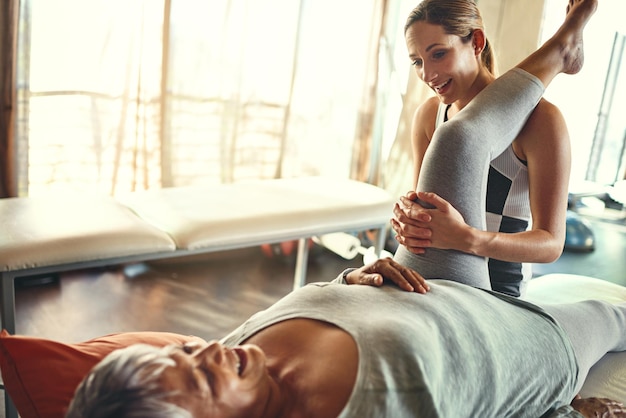 Ella está interesada en promover la buena salud Foto de una mujer mayor que está siendo tratada por un fisioterapeuta