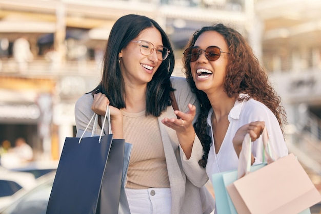 Ella lo consigue Una foto de dos mujeres jóvenes y atractivas que están afuera juntas y se unen mientras van de compras a la ciudad