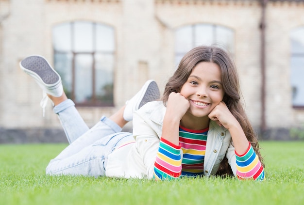 Ella se siente relajada Niño alegre con aspecto casual Final del año escolar estudiante adolescente que tiene tiempo de descanso para relajarse linda sonriente confiada colegiala felicidad infantil regreso a la escuela