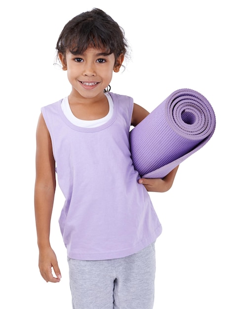 Ella tiene el gusanillo del yoga Una niña adorable de pie con su colchoneta de yoga