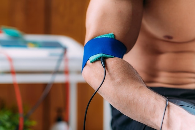 Foto ellenbogen-physiotherapie mit tens-elektroden-klammern-pads transkutane elektrische nervenstimulation