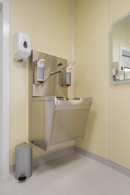 Ellenbogenseife und antiseptischer Spender oder Desinfektionsmittel an der Wand montiert zur Händedesinfektion und Wasserhahn Waschbecken mit Wasserhahn Badezimmer oder Klinik