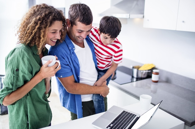 Eltern, die Laptop mit Sohn in der Küche verwenden