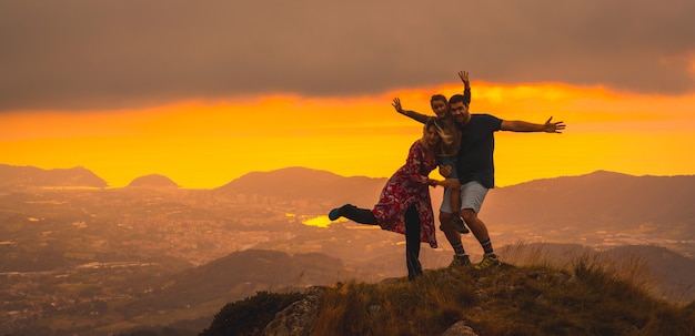 Eltern mit ihrem Sohn auf einem Berg bei Sonnenuntergang