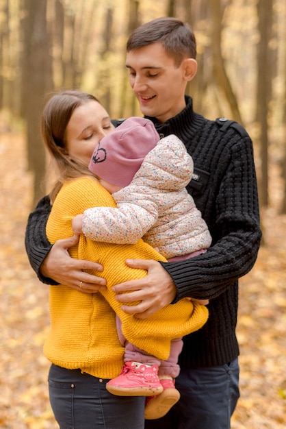 Eltern mit Tochter, die im Herbstwald spielt