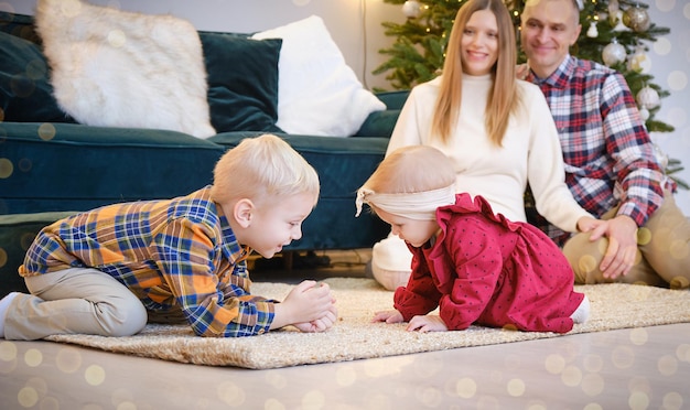 Eltern sehen ihren Kindern am Weihnachtsmorgen beim Spielen zu