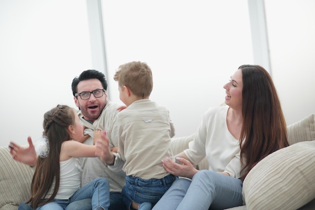 Eltern spielen mit Kindern, die auf der Couch sitzen