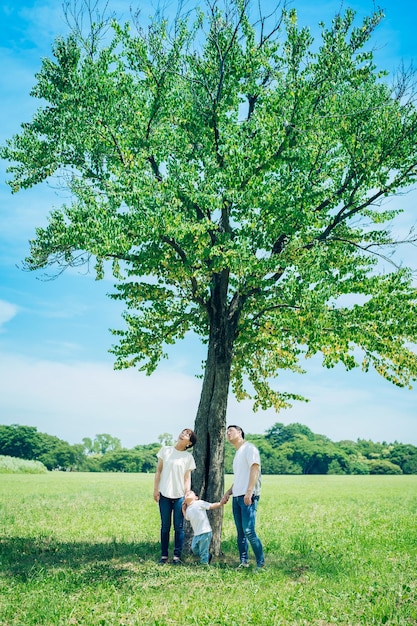 Eltern und ihr Kind aufgereiht unter einem Baum
