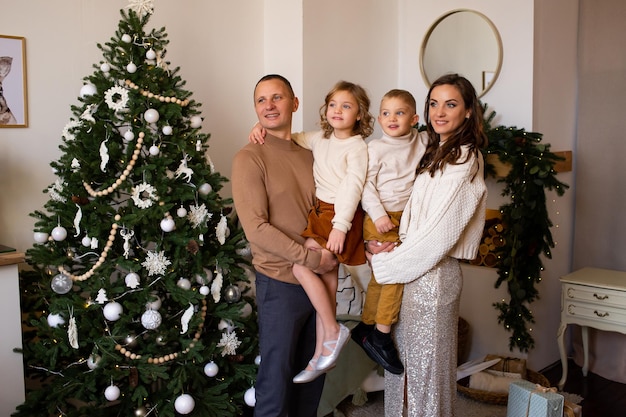 Foto eltern und ihre niedlichen kinder amüsieren sich in der weihnachtszeit drinnen