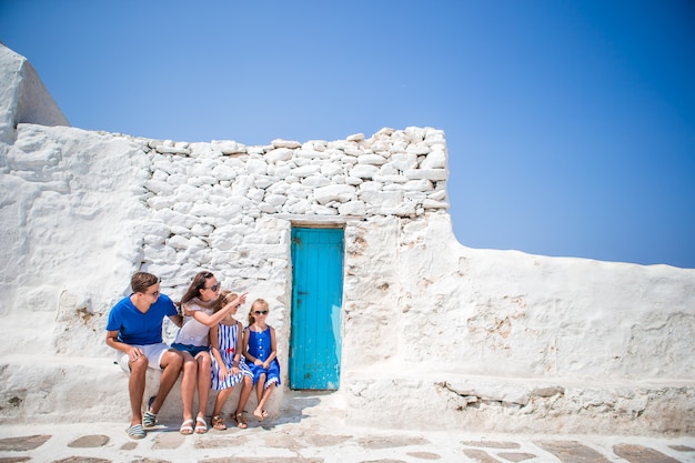 Eltern und Kinder an der Straße des typischen griechischen traditionellen Dorfs mit weißen Wänden