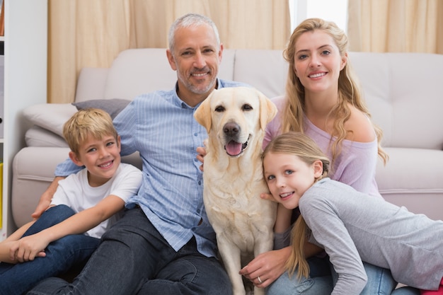 Eltern und Kinder auf Teppich mit Labrador