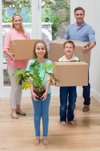 Eltern und Kinder halten Pappkartons im Wohnzimmer zu Hause