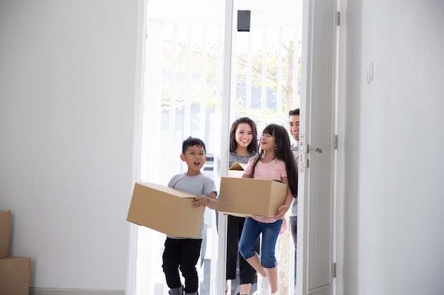 Eltern und Kinder mit Pappkarton. Umzug in ein neues Haus