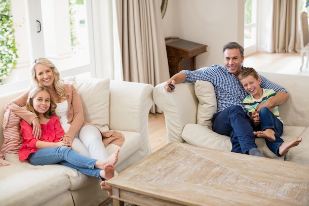 Eltern und Kinder sehen im Wohnzimmer fern