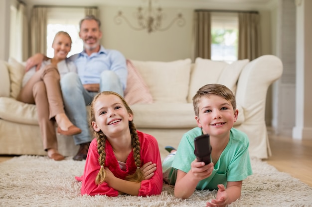 Eltern und Kinder sehen im Wohnzimmer fern