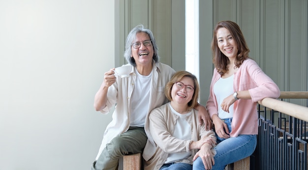 Eltern und Töchter umarmen sich glücklich im Wohnzimmer und fotografieren gemeinsam in der Familie.