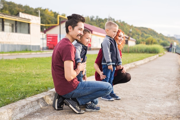 Eltern und zwei männliche Kinder gehen im Park spazieren und