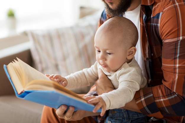 Elternschaft und Familienkonzept glücklicher Vater und kleiner Junge mit Buch zu Hause