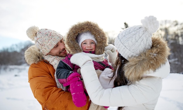 Elternschafts-, Mode-, Jahreszeit- und Leutekonzept - glückliche Familie mit Kind im Winter kleidet draußen