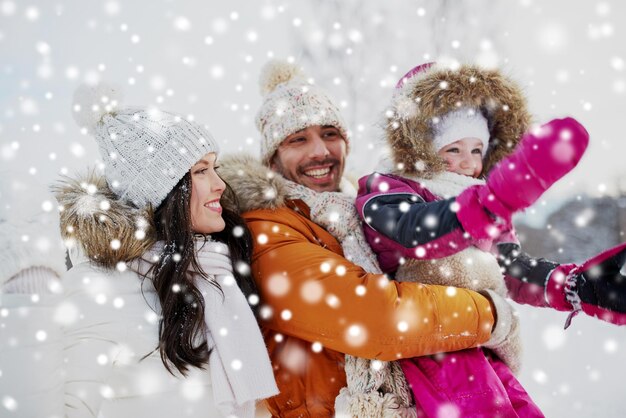 Elternschafts-, Mode-, Jahreszeit- und Leutekonzept - glückliche Familie mit Kind im Winter kleidet draußen