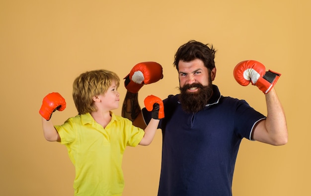 Elternschaftsbeziehung bereit für Sparring bärtiger Sportler, der Boxen kleiner Junge in Rot trainiert