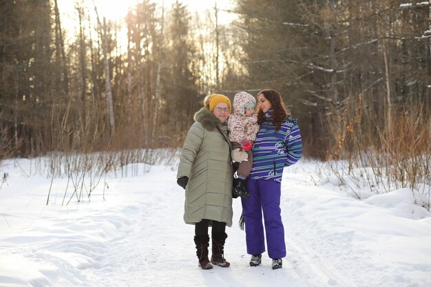 Elternteil mit Kind an den Händen im Winterpark