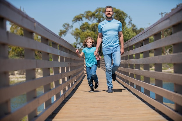 Elternteil mit kleinem Kind Junge Vater mit Kind am Sommertag Elternschaft und Vaterschaft Vatertag glücklicher Vater und Sohn laufen lustig im Freien Familienwert Kindheit und Elternschaft