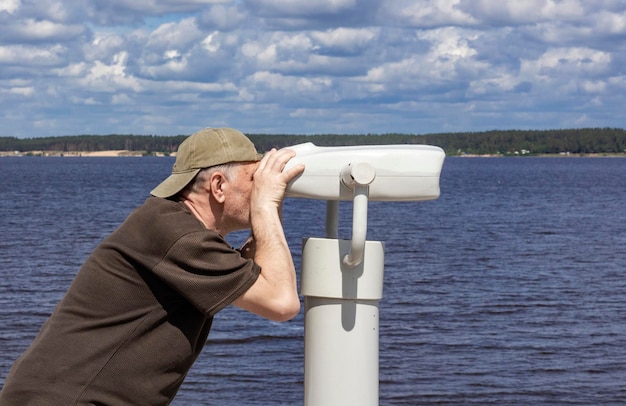 Em 19 de junho de 2022, em Cheboksary, um homem olha através de um telescópio binocular para turistas no aterro