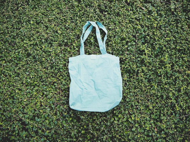 Em branco azul Mockup linho algodão Tote saco em verde arbusto árvores folhagem fundo eco natureza amigável estilo conservação ambiental reciclagem conceito modelo para obras de arte texto japonês