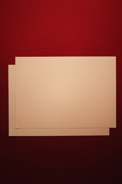 Em branco um papel bege em fundo vermelho escuro como escritório papelaria flatlay luxo branding flat lay e ...