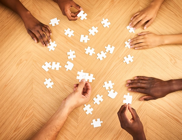 Em breve tudo fará sentido Foto recortada de um grupo de empresários completando um quebra-cabeça juntos em uma mesa