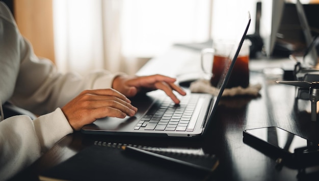 em casa escritório mão no teclado trabalhando de perto