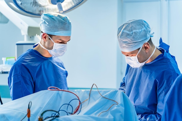 Em cirurgia Equipe médica realizando operação no centro cirúrgico do hospital Trabalhando com instrumentos cirúrgicos