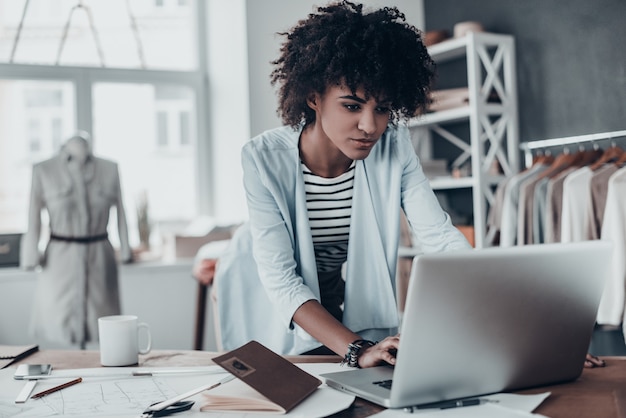 em contato com clientes. bela jovem africana trabalhando usando o computador