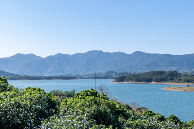 Em frente ao lago está a montanha, o céu é azul e a água do lago é azul