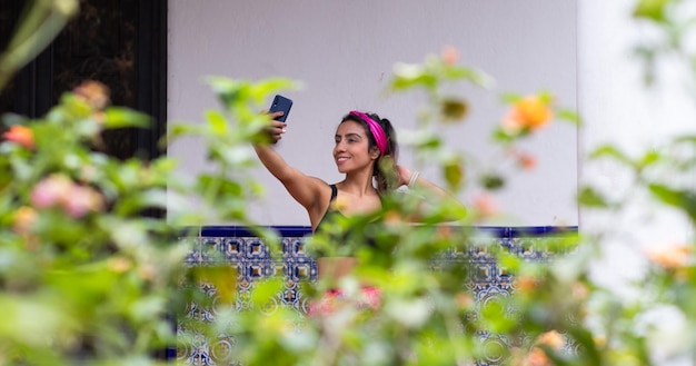 Em harmonia com a natureza, mulheres latinas tiram selfie pós-treino no jardim