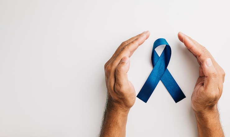 Foto em novembro, uma fita azul em mãos significa a conscientização sobre a saúde dos homens, com foco no câncer de próstata, um lembrete comovente para famílias e pacientes.