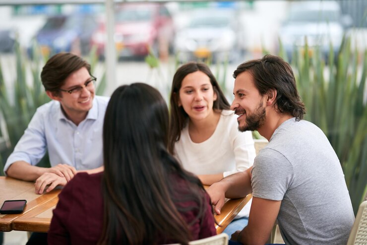 Foto em que ano foi filmado um grupo de jovens colegas de negócios alegres desfrutando de uma função de trabalho juntos em um restaurante