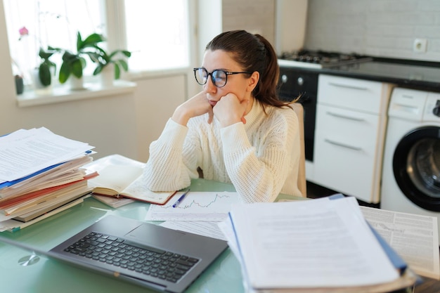 Foto em seu escritório em casa uma mulher com óculos faz uma pausa sua expressão cansada indicativa do