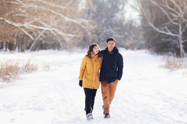 Em um dia de inverno, um jovem casal está se abraçando no parque.