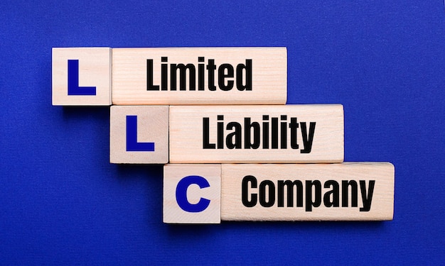 Em um fundo azul brilhante, blocos e cubos de madeira claros com o texto LLC Limited Liability Company