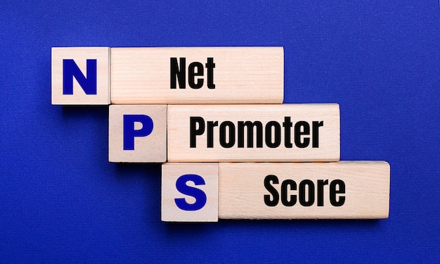 Em um fundo azul brilhante, blocos e cubos de madeira claros com o texto nps net promoter score