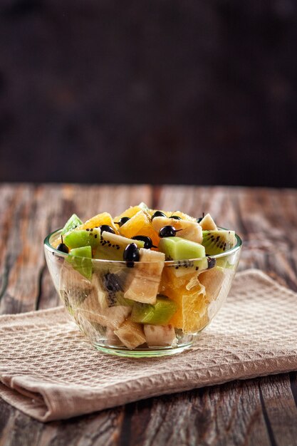 Em um fundo de madeira, salada de frutas frescas para uma dieta saudável