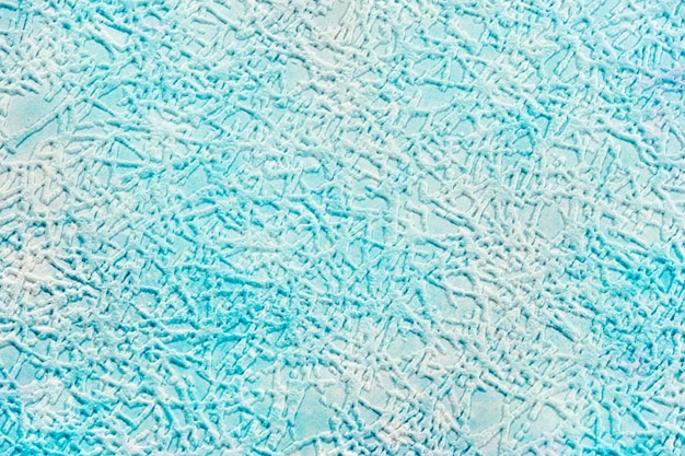 Em um fundo de papel azul claro, traços texturizados imitando gelo ou um padrão