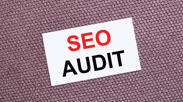 Em um fundo marrom, um cartão retangular branco com o texto seo audit