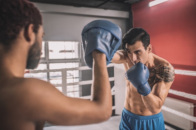 Em um ringue de boxe. kickboxers lutando em um ringue de boxe e parecendo envolvidos