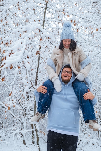 Em uma floresta coberta de neve, uma mulher está pegando carona em um homem